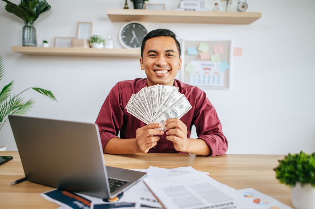 businessman holding money while smiling
